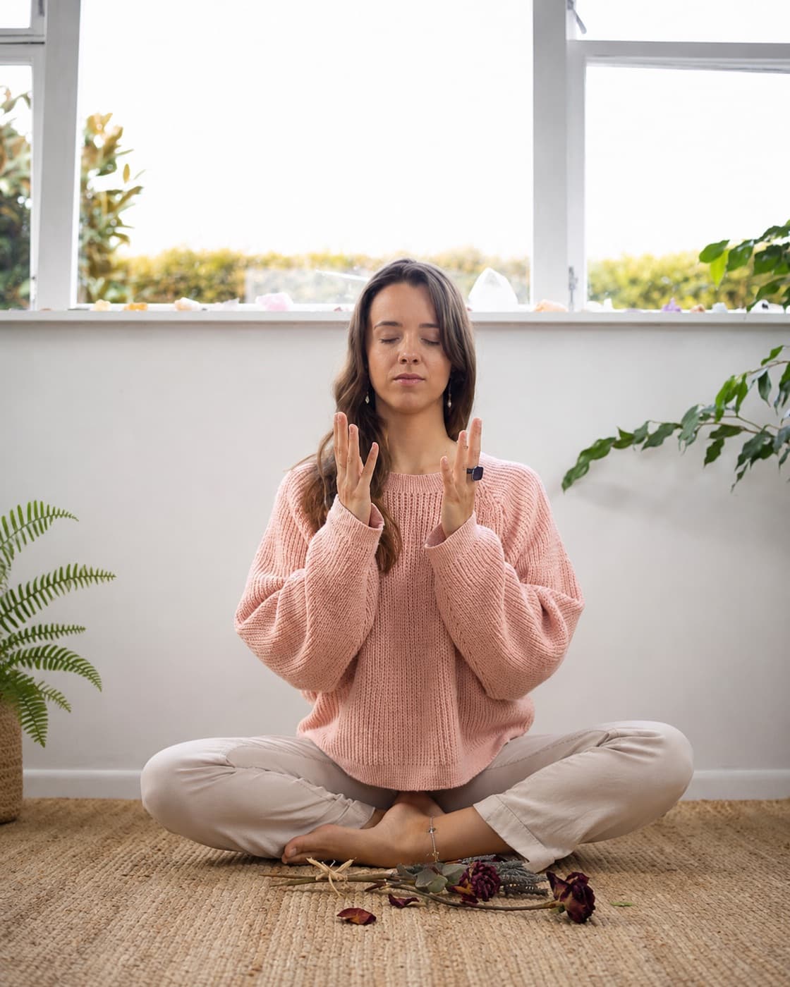 A woman meditating in stillness, receiving energy with open hands