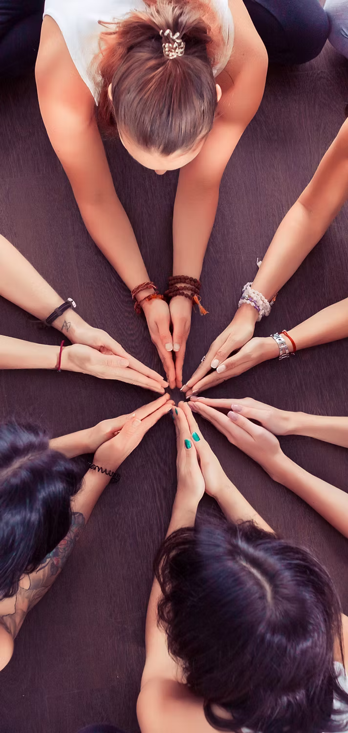 Women's hands meeting in a circle of sisterhood