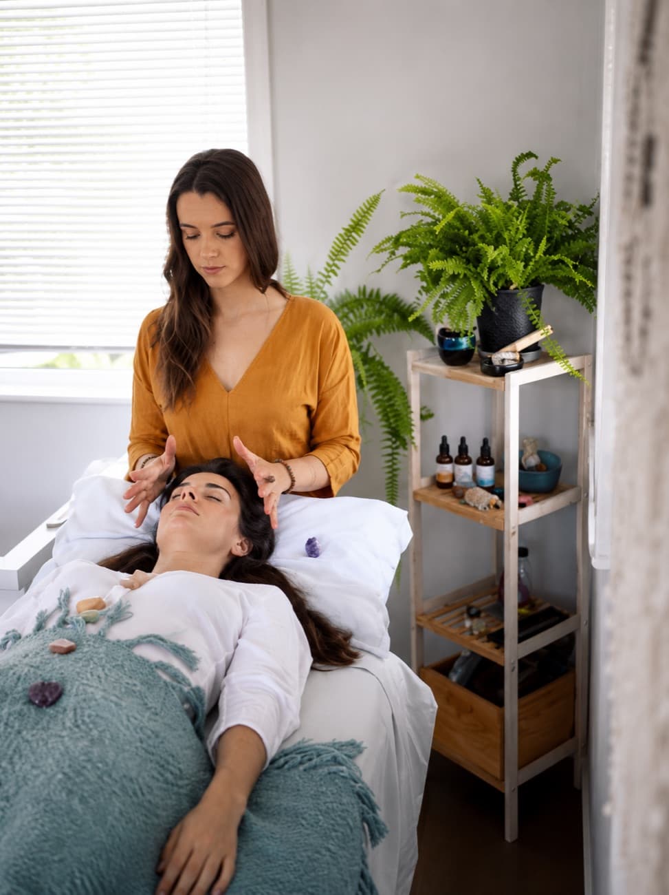 A Reiki healing session, hands held gently above a client resting on the table