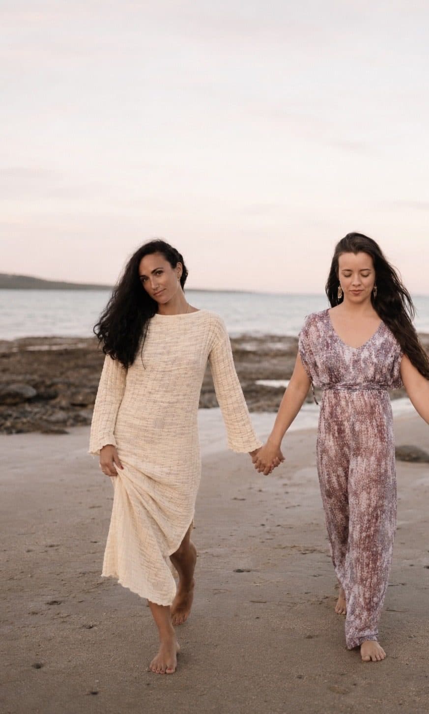 Sophia Cataldo and Sofire Harris walking hand in hand along the beach at dusk